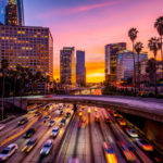 Cars in traffic in Downtown Los Angeles at sunset.