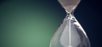 Image of an hourglass running against a green background